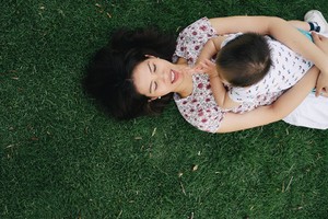 Mother and son having fun together outdoors in a park, they are playing together.