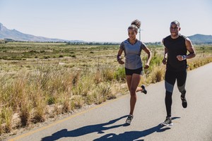 Shot of two sporty young people running out on a country road